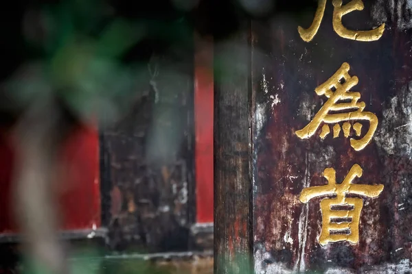 Golden chinese writing characters on a temple wall — Stock Photo, Image