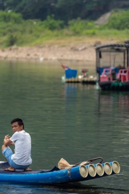 Yangshuo 'da Li Nehri' ndeki bambu teknesinde bir adam var.