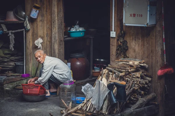 Arme oude man doet huiswerk in China — Stockfoto