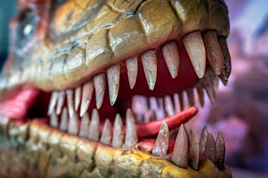 Velociraptor dinozor heykelinin ağzını aç.