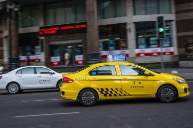 Chongqing, Çin - Ağustos 2019: Yoğun ve kalabalık caddede araba süren sarı taksi