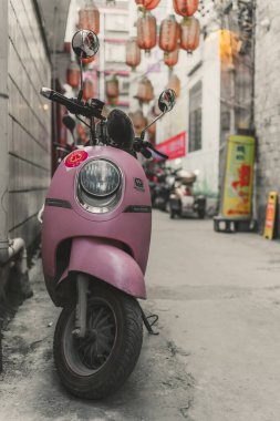 Feng Huang, Çin - Ağustos 2019: Hunan Eyaleti 'nin Feng Huang Eski Kasabası' nda dar bir geçide park edilmiş küçük pembe scooter