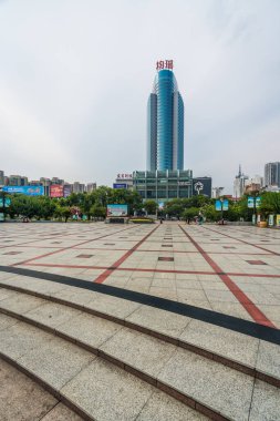 Yichang, Çin - Ağustos 2019: Hubei Eyaleti 'ndeki Yichang kasabasındaki uzun cam ve çelik ticaret binasının önündeki boş halk meydanı