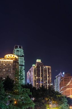Chongqing, Çin - Ağustos 2019: Geceleri Chongqing şehir merkezindeki Jiefangbei bölgesinde modern ticari ve ticari binalar aydınlatıldı