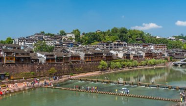 Feng Huang, Çin - Ağustos 2019: İnsanlar Tuo Tuojiang Nehri 'nden geçerek Hunan Eyaleti' nin Fenghuang Eski Kasabası 'nın merkezine akın ediyorlar.