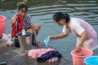Feng Huang, Çin - Ağustos 2019: Çinli kadınlar Tuo nehri kıyısında çamaşır yıkıyorlar, Feng kucaklaması