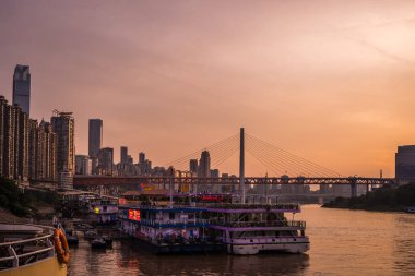 Chongqing, Çin - Ağustos 2019: Yolcu gemisi Chongqing kasabasındaki Yangtze ve Jialing nehirlerinin birleştiği yerde gün batımında yolculuğa hazır.