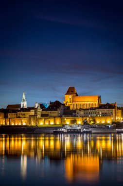 Torun's Old Town panorama with its reflection in Vistula river a clipart