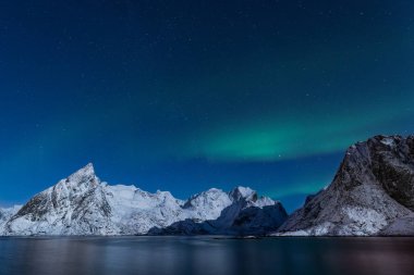 Steep winter mountains under Aurora Borealis lights in northern  clipart