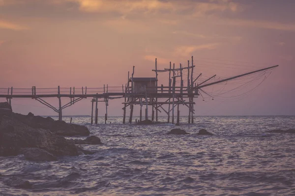 Ensam kvinna stående på trabocchi pier i nostalgisk kväll — Stockfoto