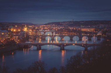 Prag 'da karamsar bir akşam. Letna Hill 'den Vltava nehri manzaralı yedi köprü. Vltava nehri üzerinde kemerli köprüleri olan eski, orta şehir manzarası