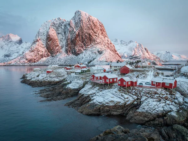 令人叹为观止的日出在Hamnoy 受欢迎的旅游目的地 冰天雪地的第一道亮光笼罩着群山和渔村的红色传统房屋 寒冷的冬日早晨北极风景 — 图库照片