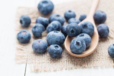 Bir tahta kaşık bir çuval üzerinde meyveleri.