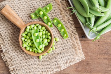 Eski ahşap arka plan, üstten görünüm üzerinde taze yeşil bezelye