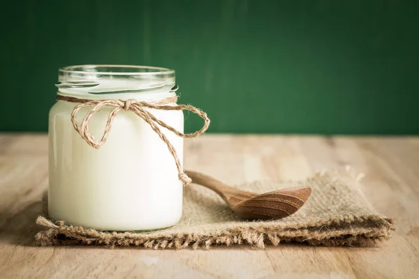 Yogur en botellas de vidrio sobre mesa de madera —  Fotos de Stock