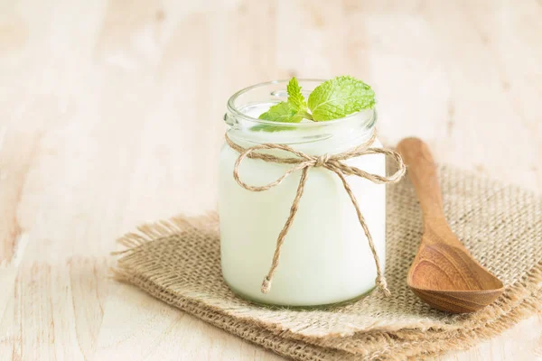 Yogur en botellas de vidrio sobre mesa de madera —  Fotos de Stock