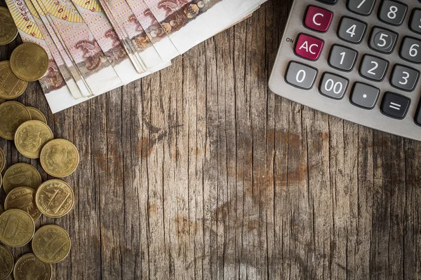 Monedas y calculadoras en la vieja mesa de madera, concepto financiero — Foto de Stock