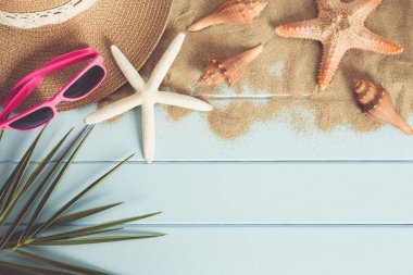 Güneş gözlüğü ve denizyıldızı mavi ahşap zemin üzerinde