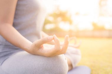 Asya kız bahçede yoga yaparken eller kadın yapmak yoga kadar yakın