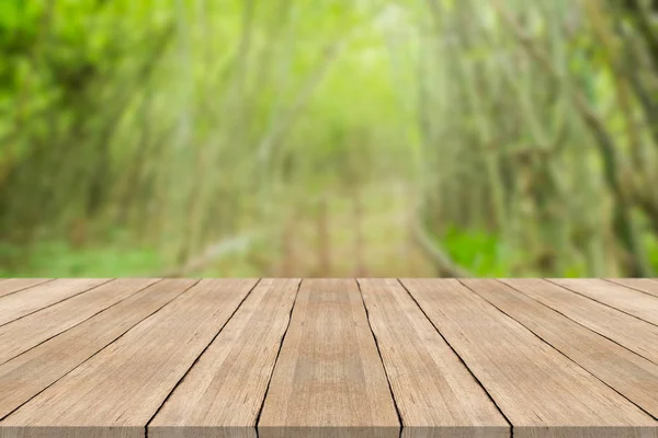 Piano tavolo in legno vuoto su sfondo verde sfocato natura — Foto Stock