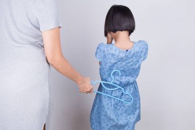 Anne kızı bir askı ile vurarak cezalandırıyor