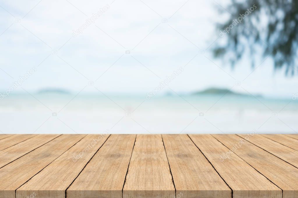 Empty wooden table in front with blurred background at the beach