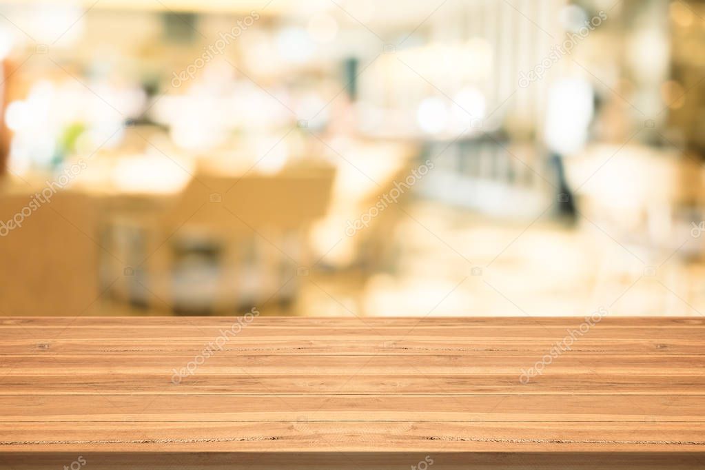 Empty wood table top on blurred background at coffee shop
