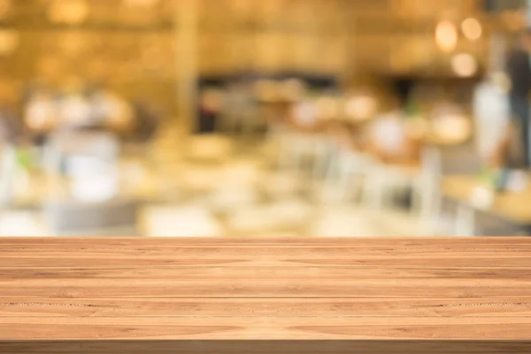 Tampo de mesa de madeira vazio no fundo borrado no café — Fotografia de Stock