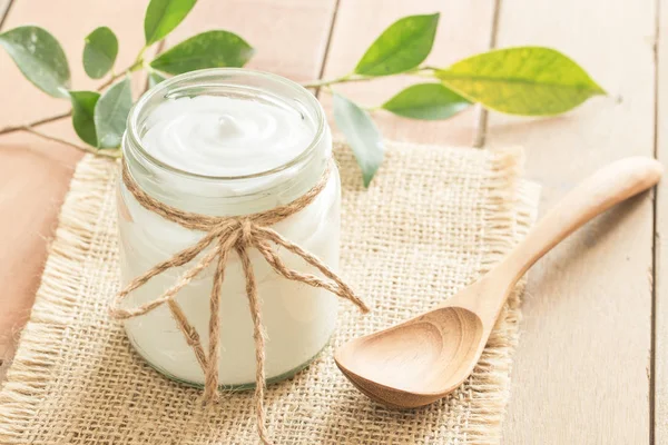 Yogur en botellas de vidrio sobre mesa de madera —  Fotos de Stock