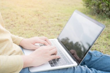 Asyalı kadınlar dizüstü yeşil çimenlerin üzerinde kullanma.