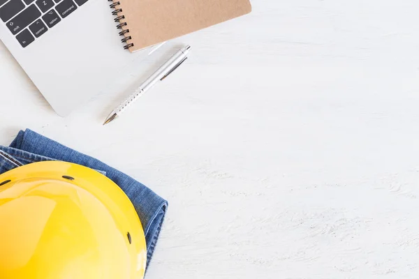 Equipment works on white wooden floor top view,Flat lay photo yellow helmet and notebook