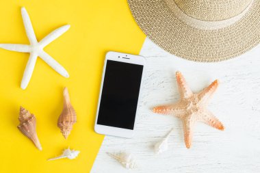 Fotoğraf smartphone ve deniz kabuğu yaz tatil tatil için sarı kağıt ve Beyaz ahşap masa üzerindeki yat, Top Üstten Görünüm