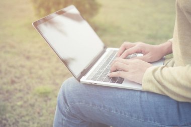 Asyalı kadınlar dizüstü yeşil çimenlerin üzerinde kullanma.