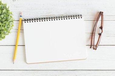 Beyaz ahşap masa üstü görünümünde boş açık defter