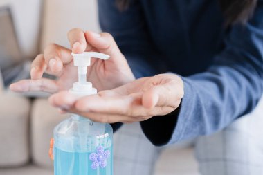 Asyalı kadınlar alkollü jel dezenfektanı ile ellerini temizler mikrop ve bakterilerin yayılmasını engeller ve virüs covid-19 'dan kaçınır.