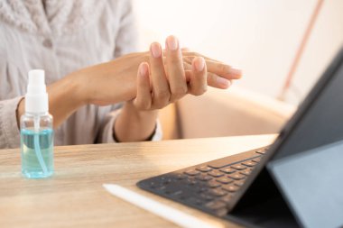 Asyalı kadınlar evde tabletini kullanmadan önce mikrop ve bakterilerin yayılmasını önler ve virüsün bulaşmasını engeller.