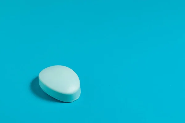 Mavi arka planda sabun. Ellerini sabunla yıkayarak sağlık ve hijyeni virüslerden, bakterilerden, gripten ve coronavirüs covid-19 'dan korumak.