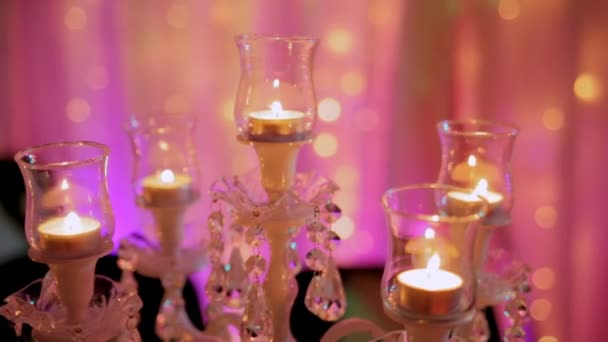 Κηροπήγια με αναμμένα κεριά το βράδυ στην αίθουσα — Αρχείο Βίντεο