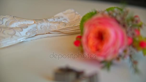 On the table lay a beautiful boutonniere and cufflinks — Stock Video