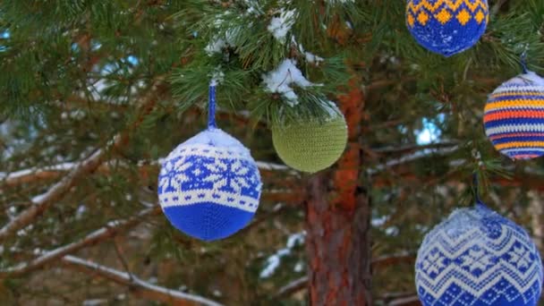 Bolas de Navidad colgando de ramas de pino cubiertas de nieve — Vídeos de Stock