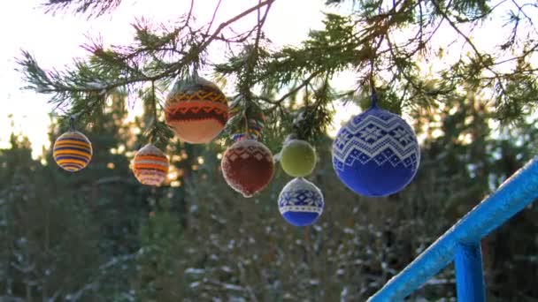 Kerstballen in hangen van pijnboomtakken bedekt met sneeuw — Stockvideo