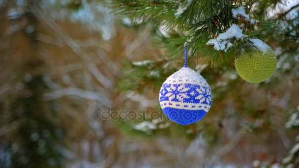 Bolas de Navidad colgando de ramas de pino cubiertas de nieve — Vídeos de Stock