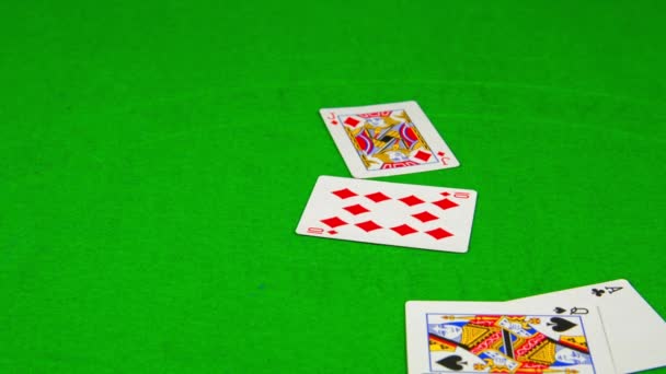 Игральные карты падают на зеленый стол — стоковое видео