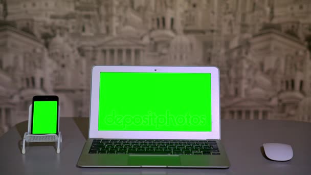 Laptop auf dem Tisch, Smartphone auf dem Ständer, chromakey — Stockvideo