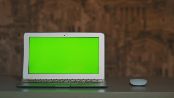 The laptop is on the table, lying next to the mouse the chromakey — Stock Video