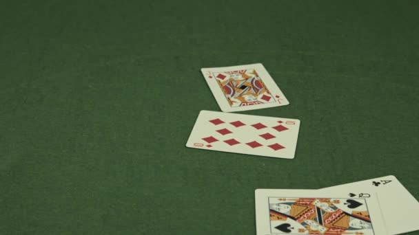 Игральные карты падают на зеленый стол — стоковое видео