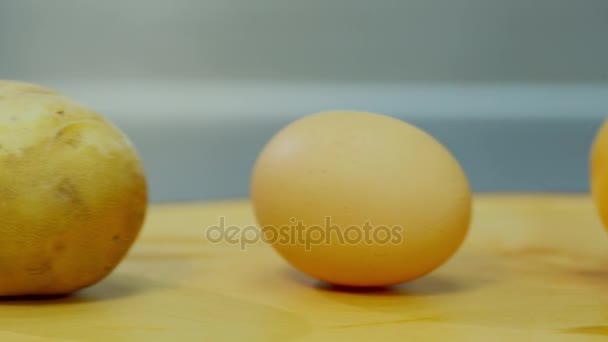 Patatas, cebolla, huevo y harina tumbados en un soporte de madera — Vídeo de stock