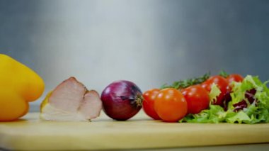 dolmalık biber, pastırma, soğan, domates ve marul, bir ahşap stand üzerine yalan