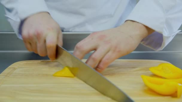 Шеф-повар нарезает желтый перец — стоковое видео
