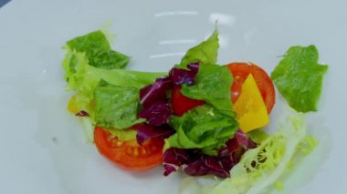 Şef salata bir kase koyar.